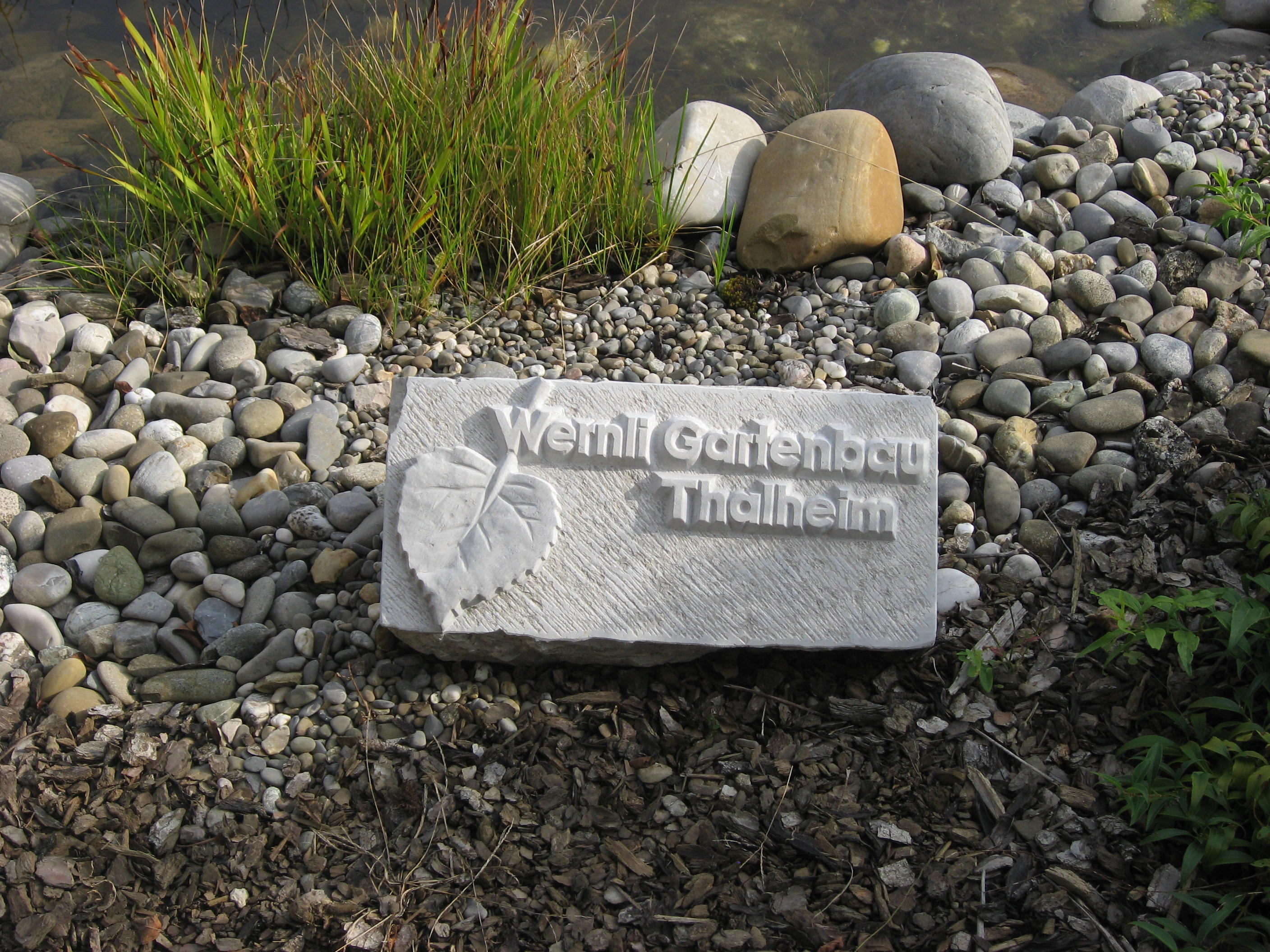 Kalksteingravur mit Wernli Gartenbau Logo